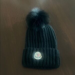 Authentic. Moncler Black Ribbed Beanie with a Faux Fur Pom Pom. New with tags.